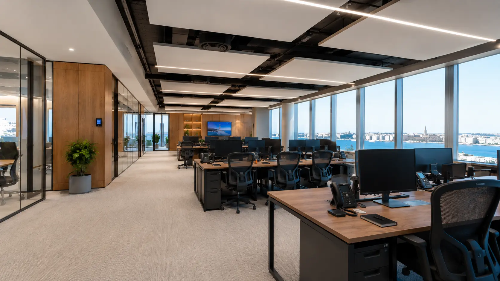 Modern office design in Malta featuring open-plan workstations, ergonomic office furniture, wooden finishes, and panoramic sea-view office interior